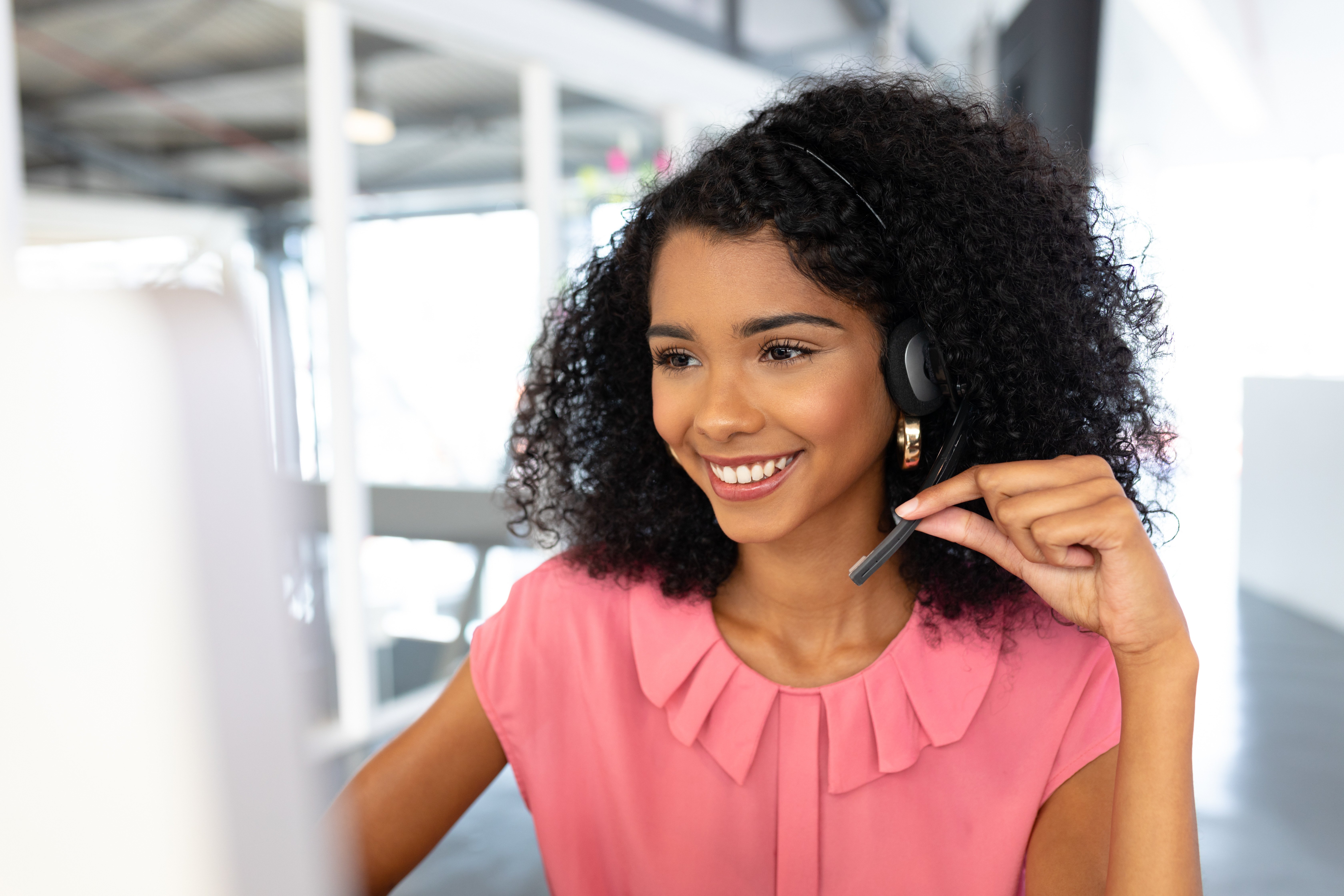 A smiling contact center agent at their workstation