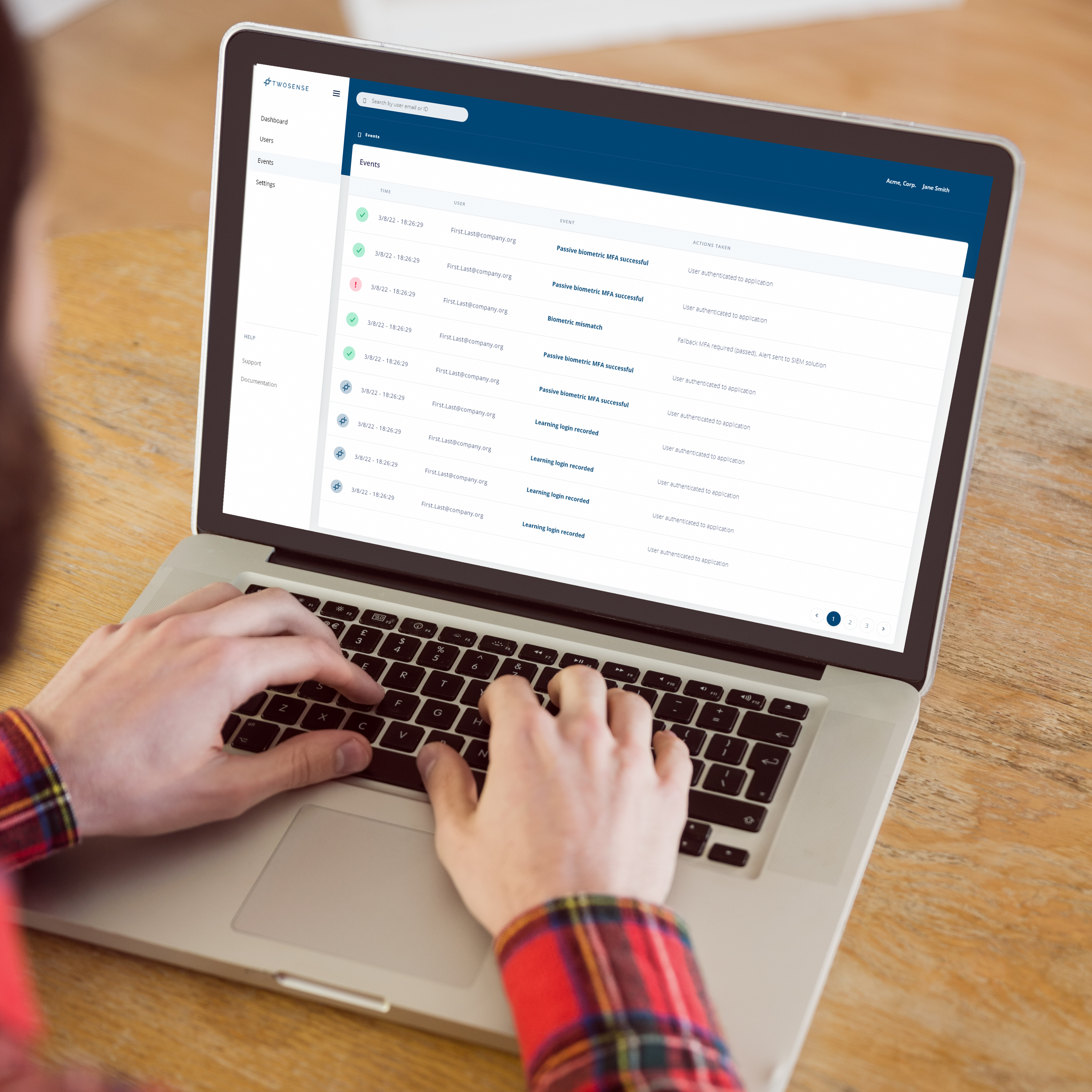 A person is typing on a laptop displaying the Twosense dashboard, which features a list of security events.